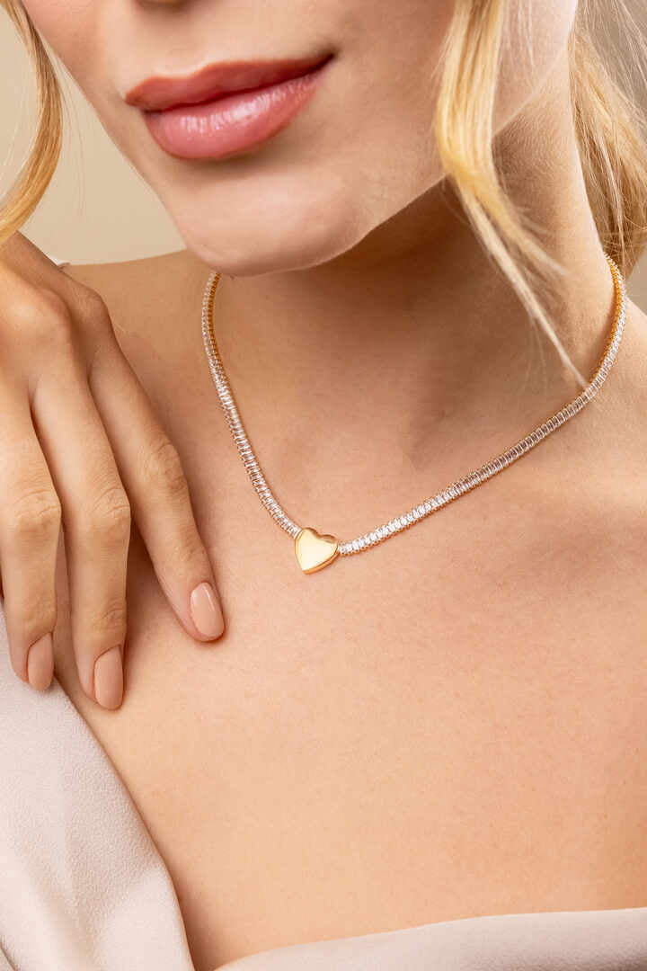Colar - Choker de Baguete com Coração Colar tipo choker com zircônias baguete e pingente de coração central. Brilho e romantismo em uma peca de presença.